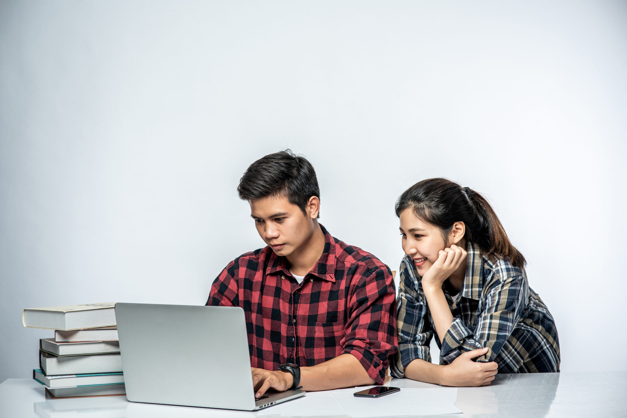 Women teach men how to work with laptops at work.